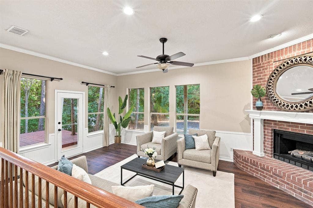7030 Pecan Creek Circle, Midlothian, TX 76065 Charming sitting room with a vaulted ceiling, ceiling fan, cozy brick fireplace, and French doors opening to the backyard, a perfect spot to unwind.