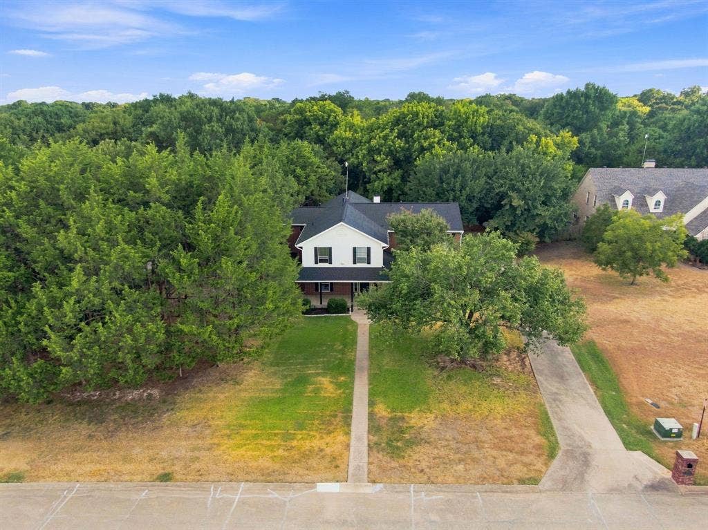 7030 Pecan Creek Circle, Midlothian, TX 76065 Treetop aerial view showcasing the home's gabled roofline nestled among mature, established trees for wonderful privacy and shade.