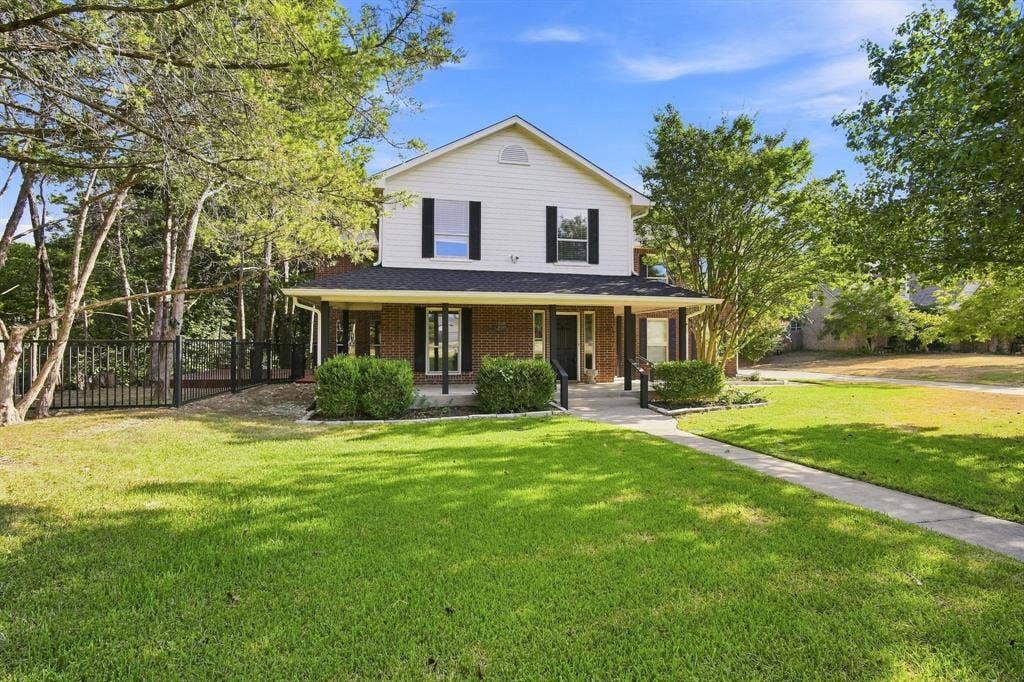 7030 Pecan Creek Circle, Midlothian, TX 76065 A striking two-story exterior with brick and siding, a columned front porch, and a classic gabled roofline welcomes you home.