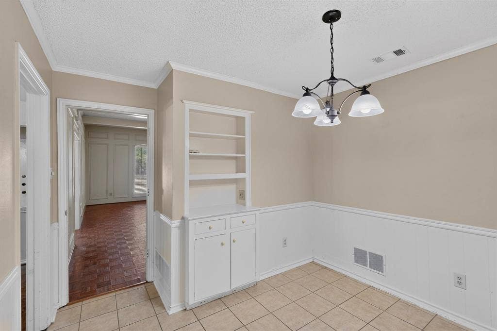 1606 Treehouse Lane, Plano, TX 75023 Tile flooring, a built-in cabinet with shelving, wainscoting, and a chandelier