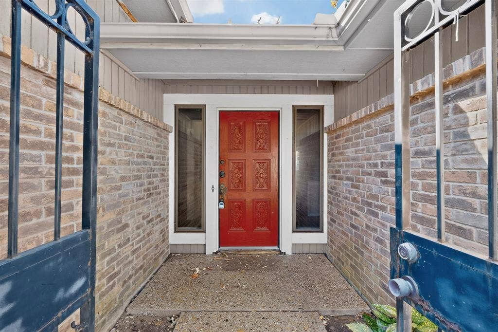 1606 Treehouse Lane, Plano, TX 75023 Covered entry with decorative iron gate and brick enclosure