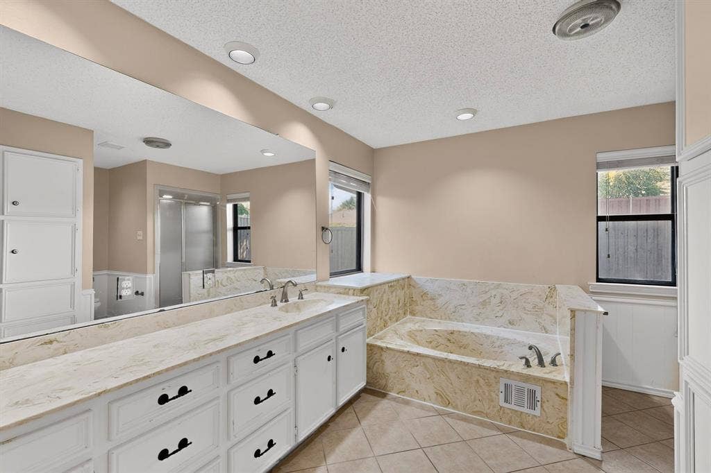 1606 Treehouse Lane, Plano, TX 75023 Expansive vanity with dual undermount sinks, stone-finish countertop, and full-wall mirror