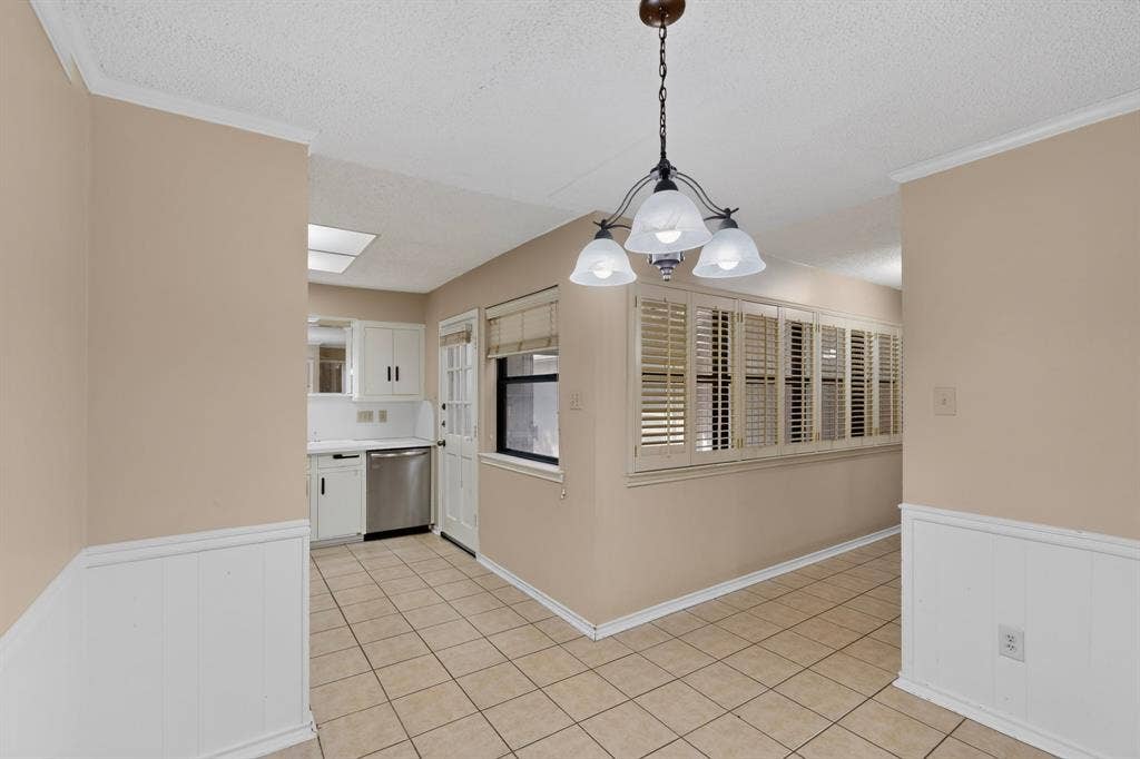 1606 Treehouse Lane, Plano, TX 75023 Tiled flooring, wainscoting, wood-finish plantation shutters, ceiling-mounted light fixture, and white cabinetry