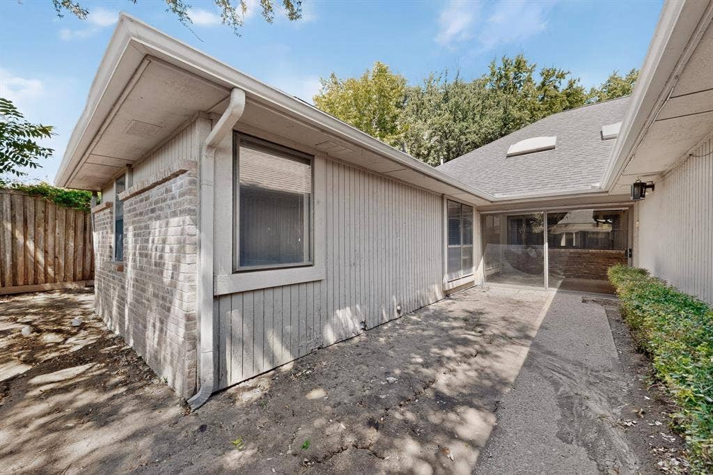 1606 Treehouse Lane, Plano, TX 75023 Exterior featuring brick and vertical panel siding, a screened-in patio, concrete pathway, and mature landscaping
