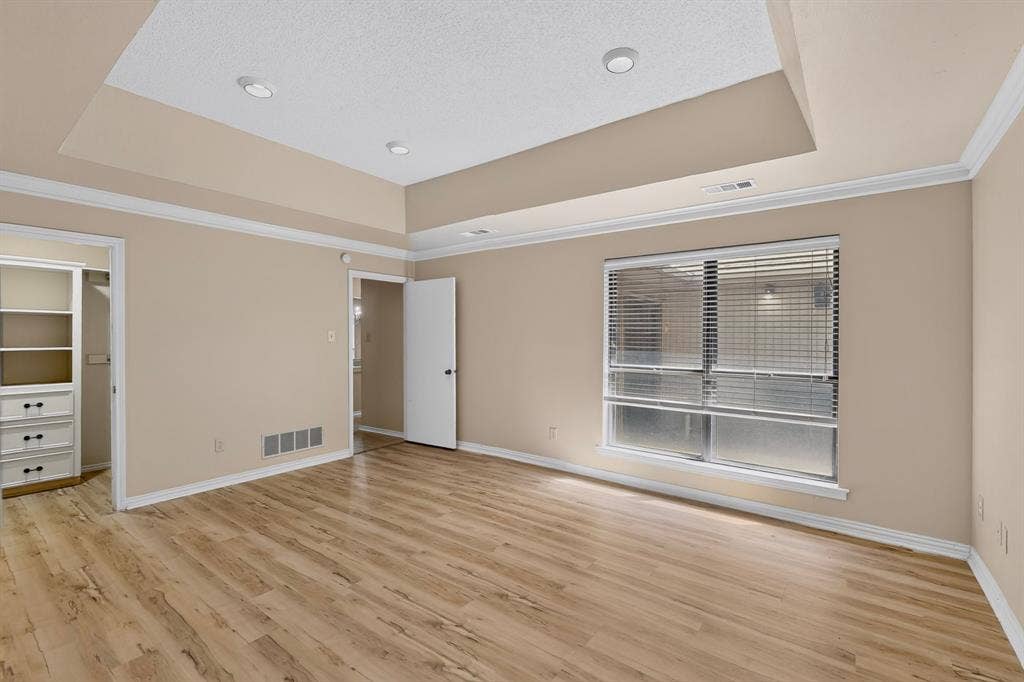 1606 Treehouse Lane, Plano, TX 75023 Recessed lighting, crown molding, a tray ceiling, wood-finish flooring, and built-in closet shelving