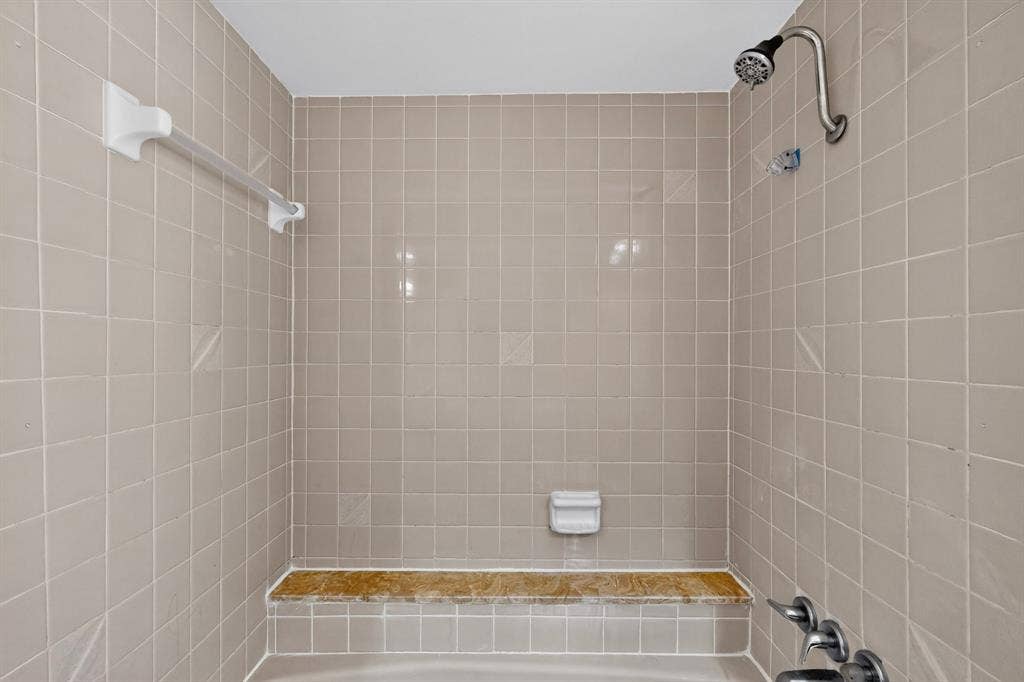 1606 Treehouse Lane, Plano, TX 75023 Tiled shower surround with an integrated shower bench and a chrome shower fixture