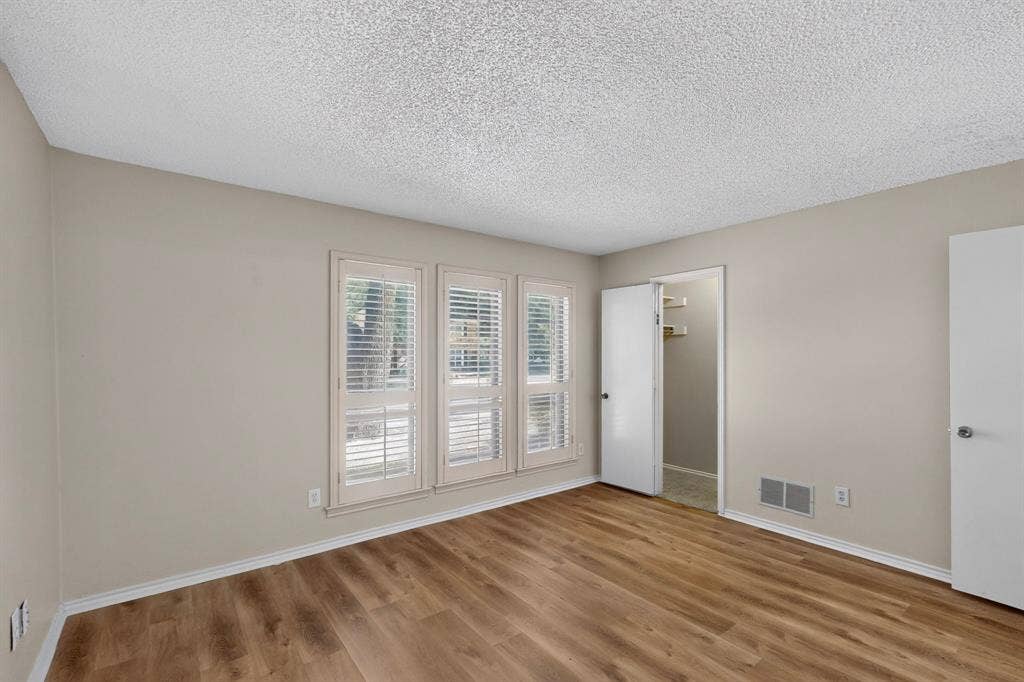 1606 Treehouse Lane, Plano, TX 75023 Wood-finish flooring, neutral wall paint, and white trim
