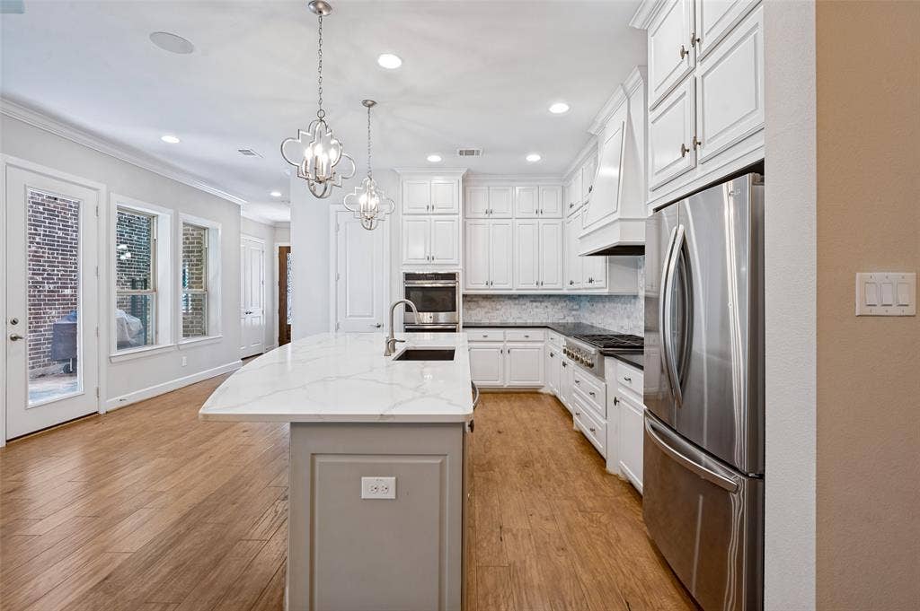 Stunning kitchen showcases extensive white cabinetry with abundant storage.