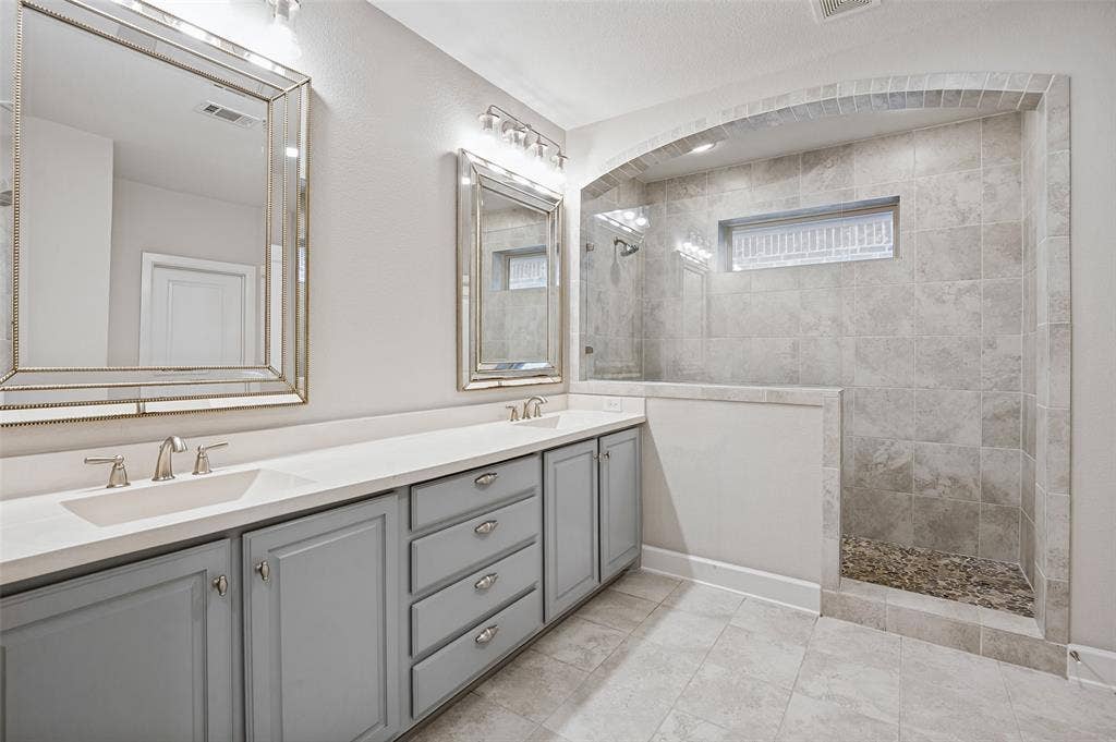 Spa-inspired primary bath features a luxurious walk-in shower, wrapped in elegant tilework.