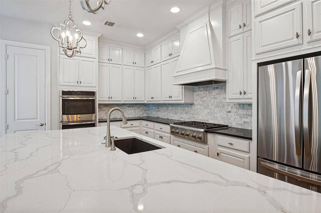 Beautifully equipped with SS appliances, including a double convection oven and built-in microwave, complemented by striking countertops and polished finishes.