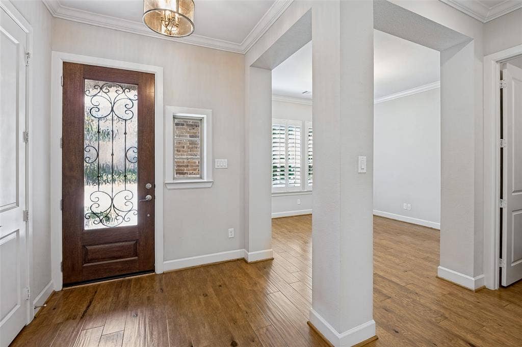 Light-filled entry with rich hardwood floors, soaring ceilings & graceful architectural details that set the tone for the home.