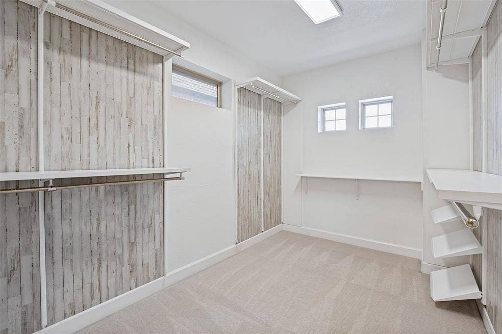 Impressive walk-in closet offers extensive built-in shelving & storage, creating a beautifully organized extension of the primary suite.