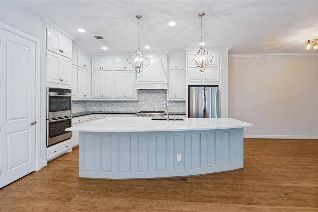 Large center island anchors the kitchen with abundant prep & gathering space, plus a custom walk-in pantry for exceptional storage.
