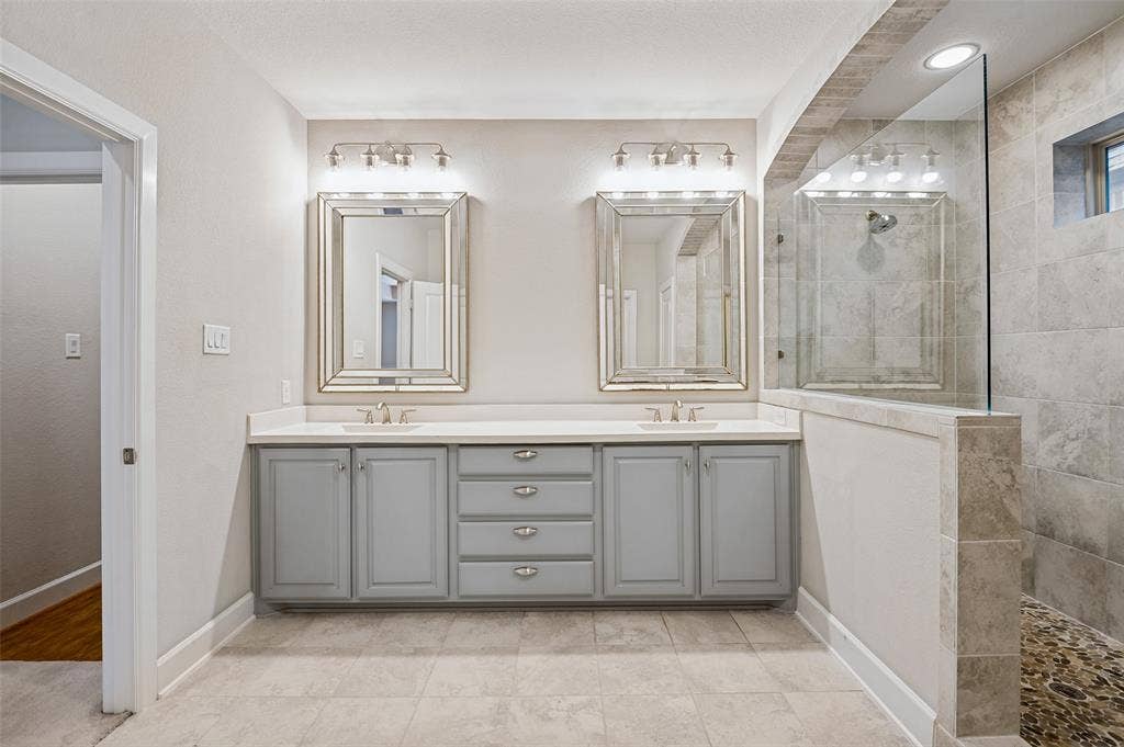 The primary bath features an expansive dual-sink vanity and generous storage.
