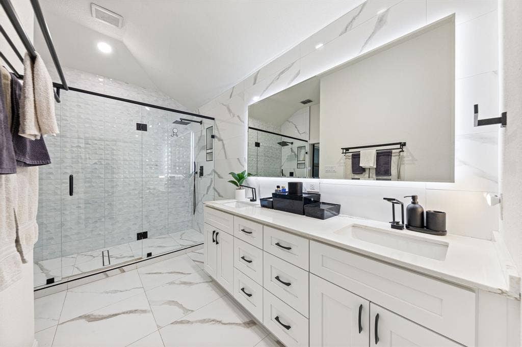 7011 Nueces Drive, Irving, TX 75039 Dual sink vanity with white cabinetry and quartz countertops