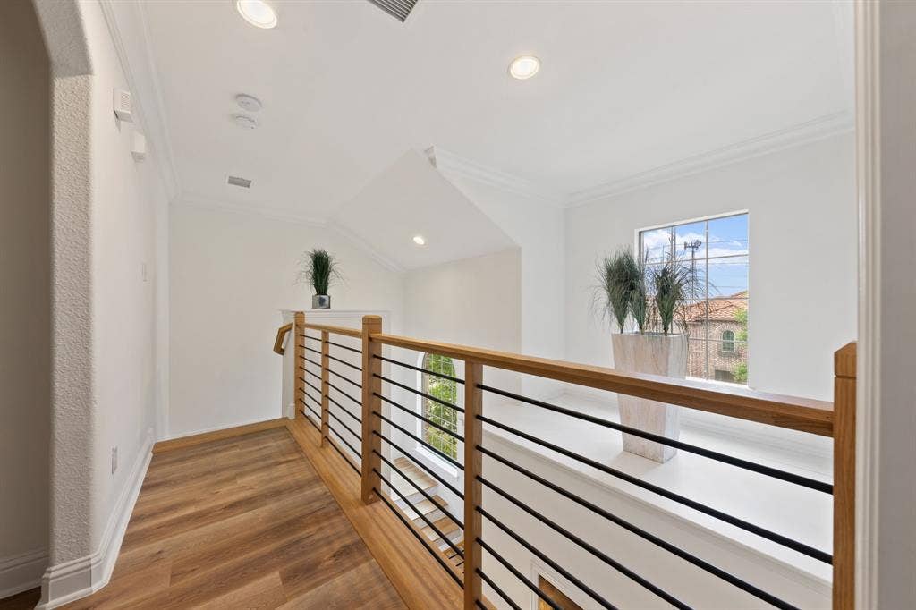 7011 Nueces Drive, Irving, TX 75039 Wood-finish flooring, recessed lighting, crown molding, a window with exterior views, and a wood and metal railing