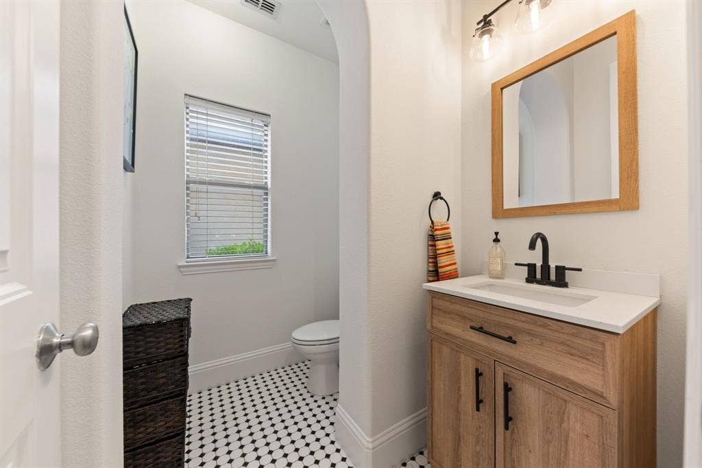 7011 Nueces Drive, Irving, TX 75039 Wood-finish vanity with a white countertop and rectangular sink