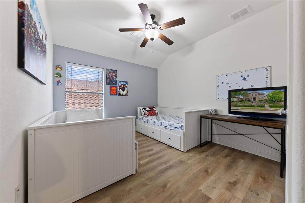 7011 Nueces Drive, Irving, TX 75039 Vaulted ceiling with a ceiling fan, wood-finish flooring, and a window with blinds