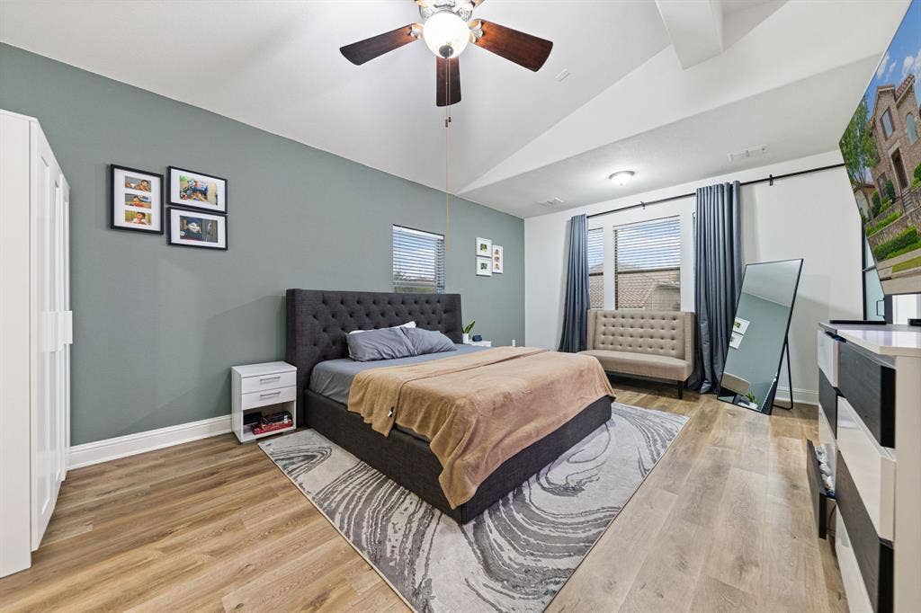 7011 Nueces Drive, Irving, TX 75039 Vaulted ceiling with a ceiling fan, wood-finish flooring, and white trim
