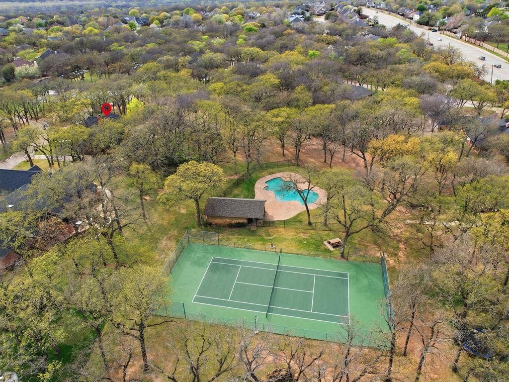 Community tennis court and pool located behind the home