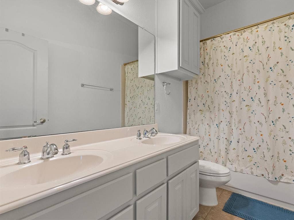 Upstairs full bathroom with dual sinks, shower/tub combo, and built-in storage