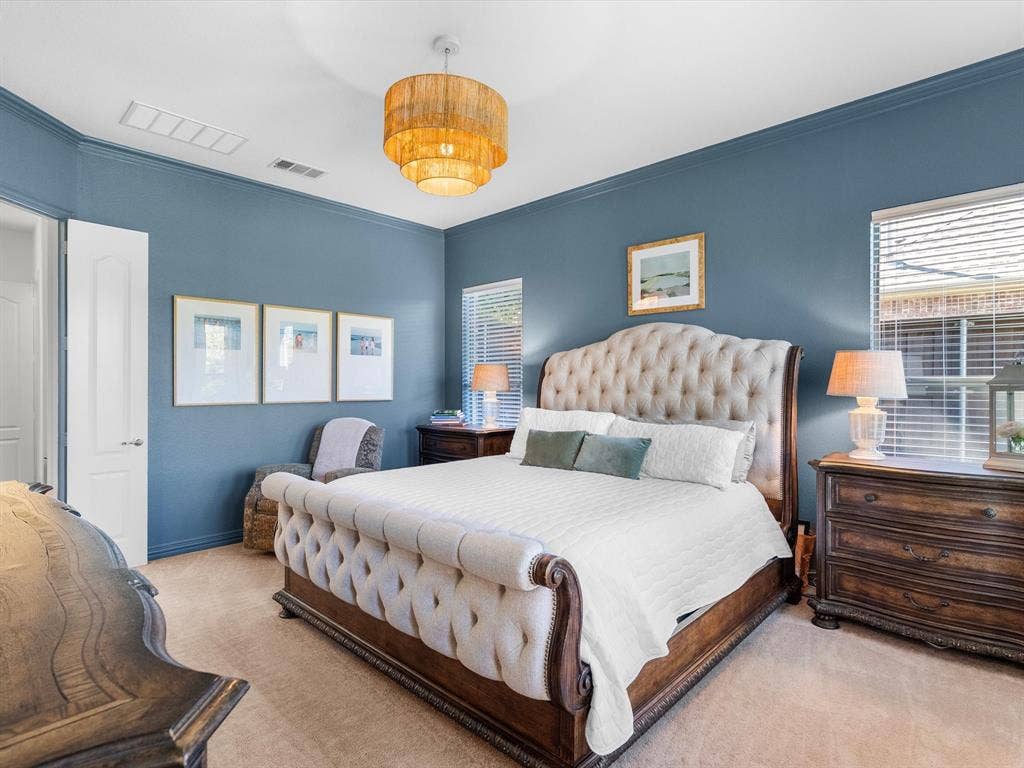 Private, first-level primary bedroom is spacious and off of the main living space with updated lighting and views of the backyard