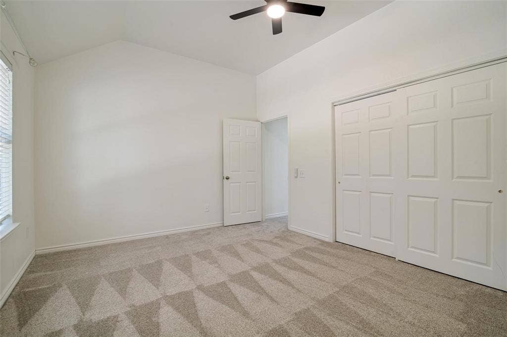 1516 Cedar Grove Court, Allen, TX 75002 Vaulted ceiling with a ceiling fan, patterned carpet flooring, sliding closet doors, and window blinds