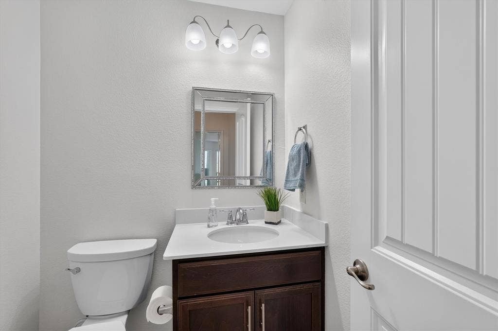 White vanity with an integrated sink, dark wood-finish cabinetry, and a chrome faucet