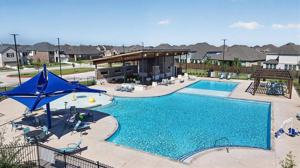 Community swimming pool featuring multiple depths and a shallow splash pad