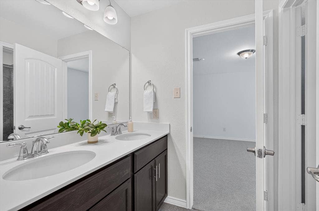 Double vanity with undermount sinks, chrome fixtures, and dark wood-finish cabinetry