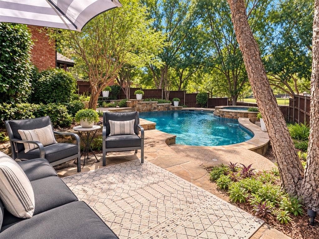 2912 Meadow Glen Drive, Flower Mound, TX 75022 Curved swimming pool with an integrated spa, surrounded by stone coping and hardscaping