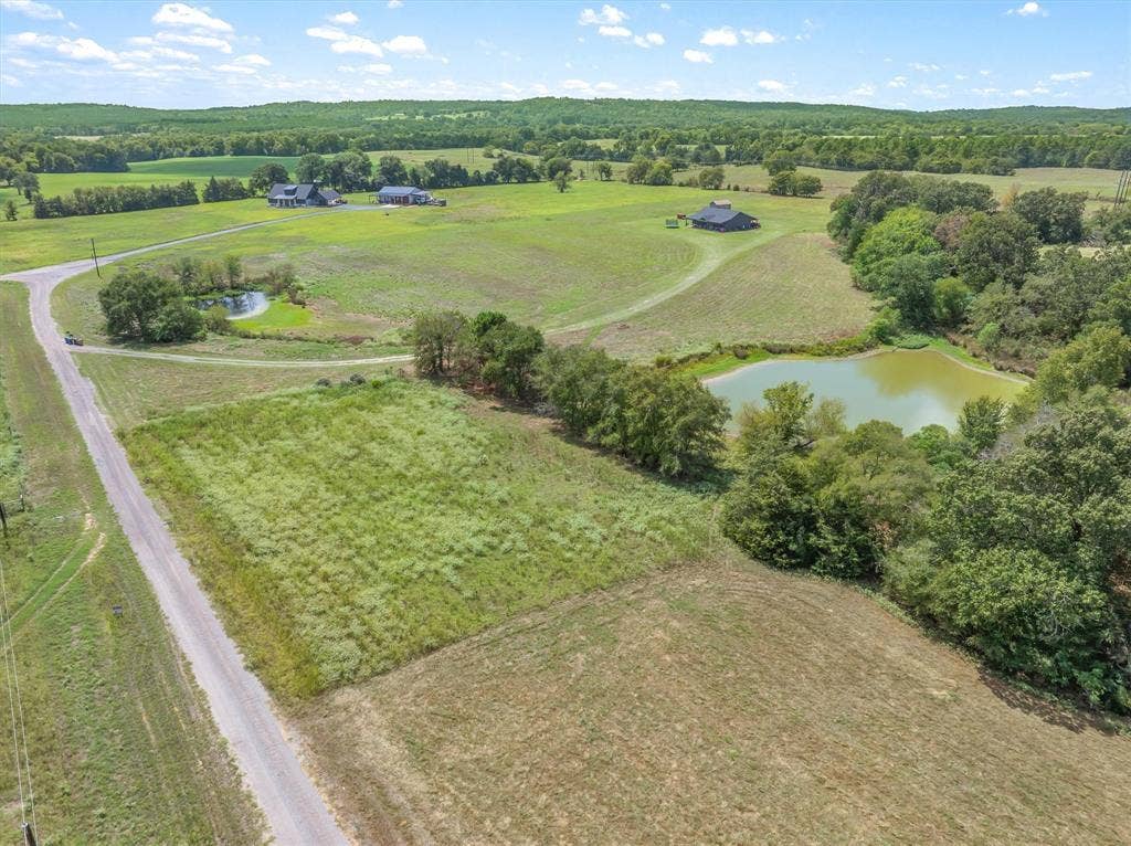 24670 Private Road 8102, Frankston, TX 75763 Extensive acreage featuring a gravel road, two distinct ponds, and scattered mature trees