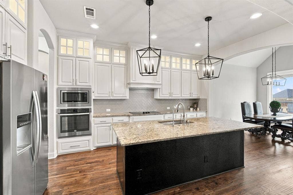 5620 Limestone Lane, Midlothian, TX 76065 Kitchen is a chef's dream with hardwood floors, upper cabinet lighting, granite countertops, and beautiful lighting