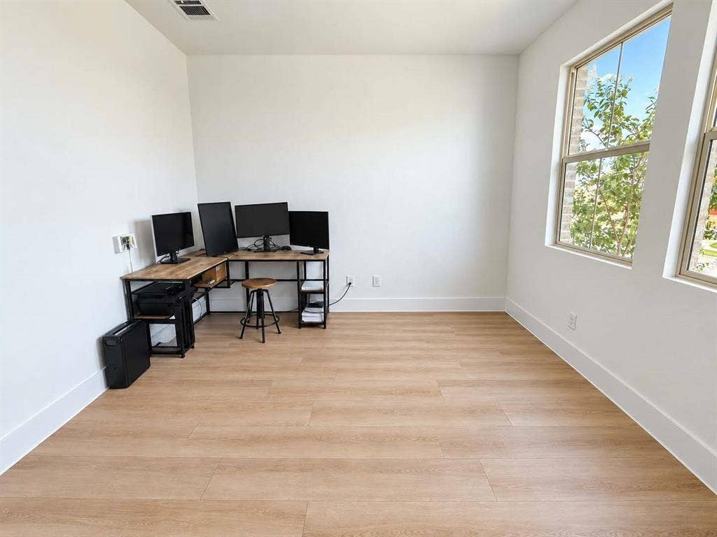 1411 Potenza Road, Fate, TX 75087 Expansive room featuring light wood-finish flooring and multiple large windows