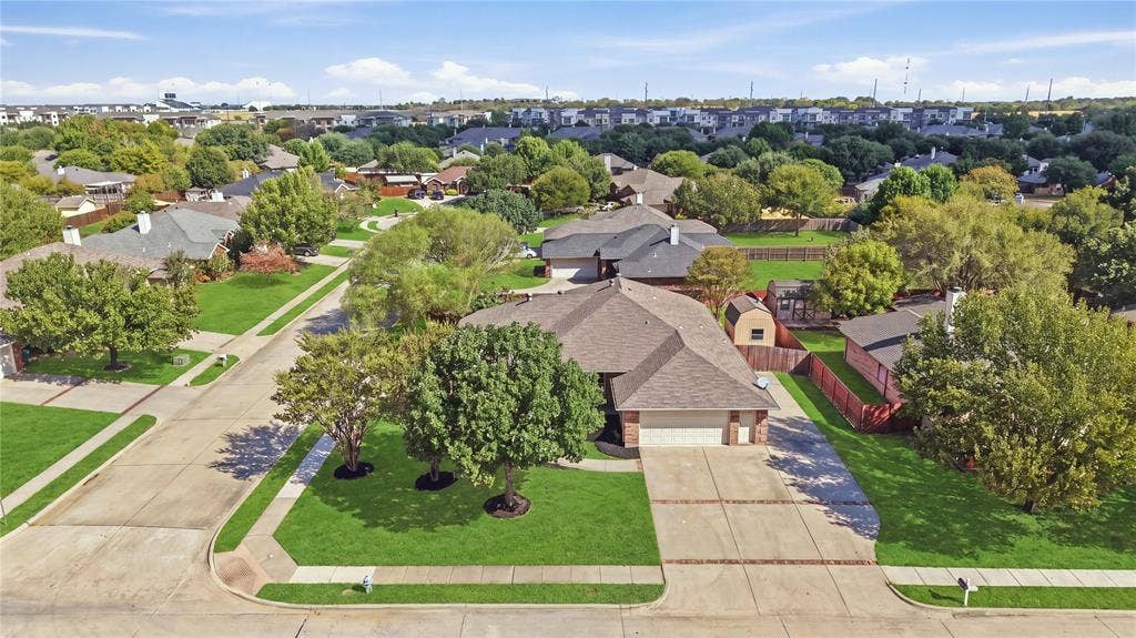 Brick exterior with a gabled roof, attached two-car garage, concrete driveway, and established landscaping
