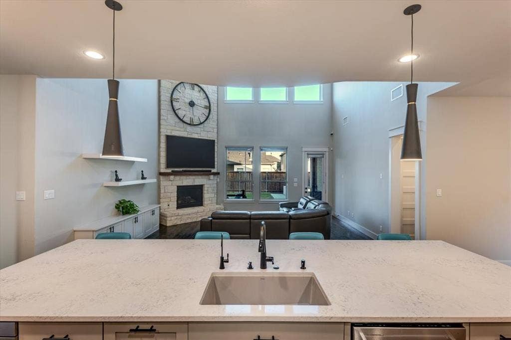 4102 Parkview Boulevard, Celina, TX 75009 Open-concept living space featuring a stone-clad fireplace and high ceilings