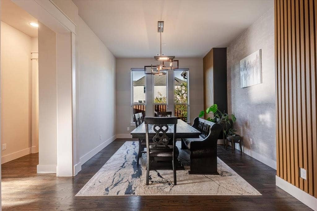 4102 Parkview Boulevard, Celina, TX 75009 Dining area featuring wood-finish flooring, a contemporary chandelier, multiple windows, and a wood slat accent wall