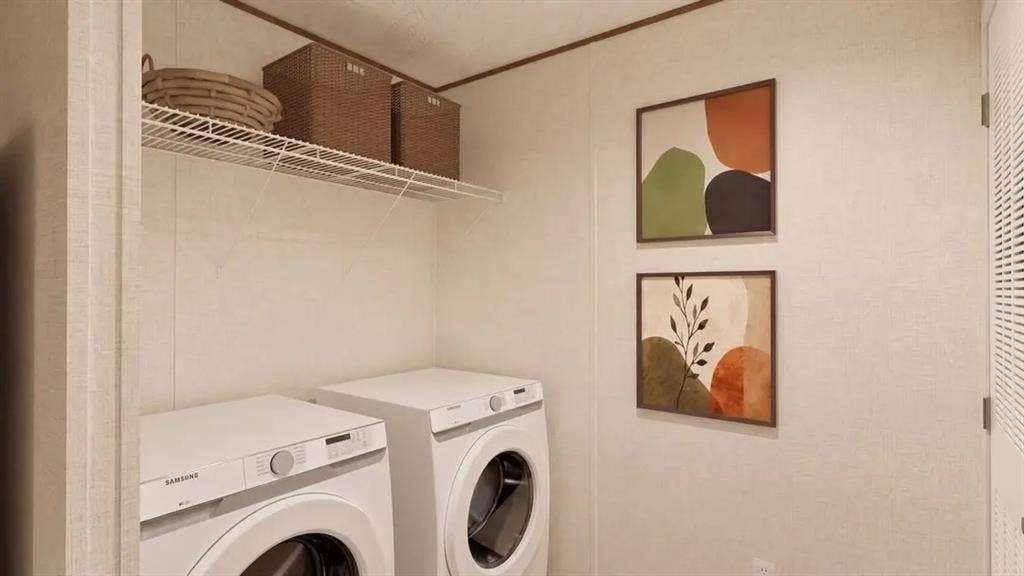 Laundry area featuring high-efficiency front-loading washer and dryer, white paneling, and elevated wire shelving