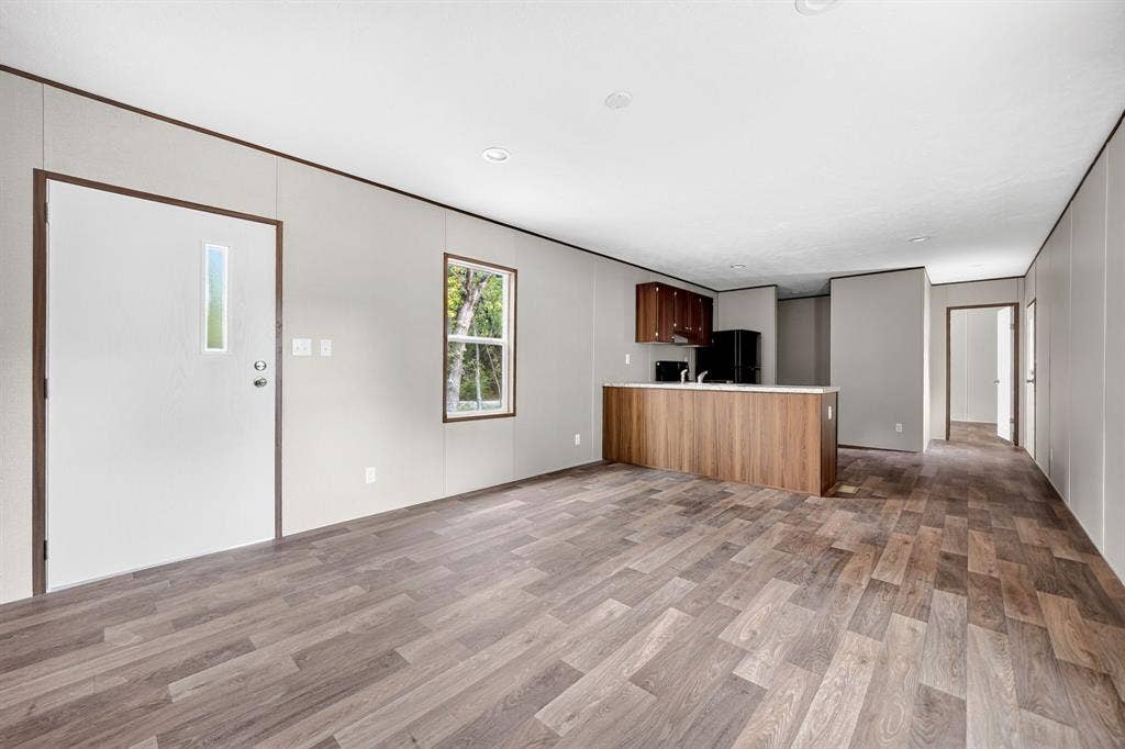 Open-concept interior featuring wood-finish flooring, recessed lighting, and a kitchen island with built-in cabinetry