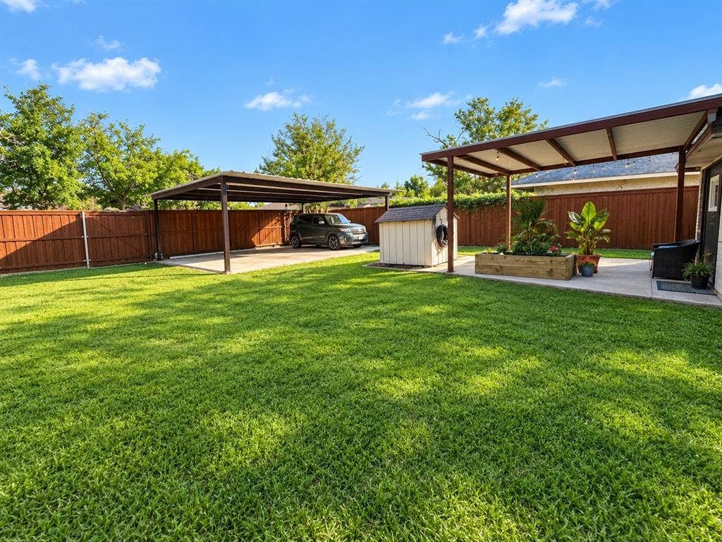 Expansive backyard featuring a manicured lawn, full privacy fencing, and two covered patio structures