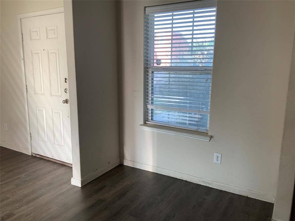 1030 Stanwyck Avenue, Duncanville, TX 75137 Wood-finish flooring with a white entry door featuring panel detailing