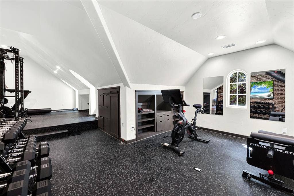 5237 SKY LAKE Drive, Plano, TX 75093 Angled rooflines create cozy architectural zones, while a charming arched window draws bright sunlight across the dark, resilient flooring. Start your day with an invigorating sunrise workout in this naturally lit retreat.
