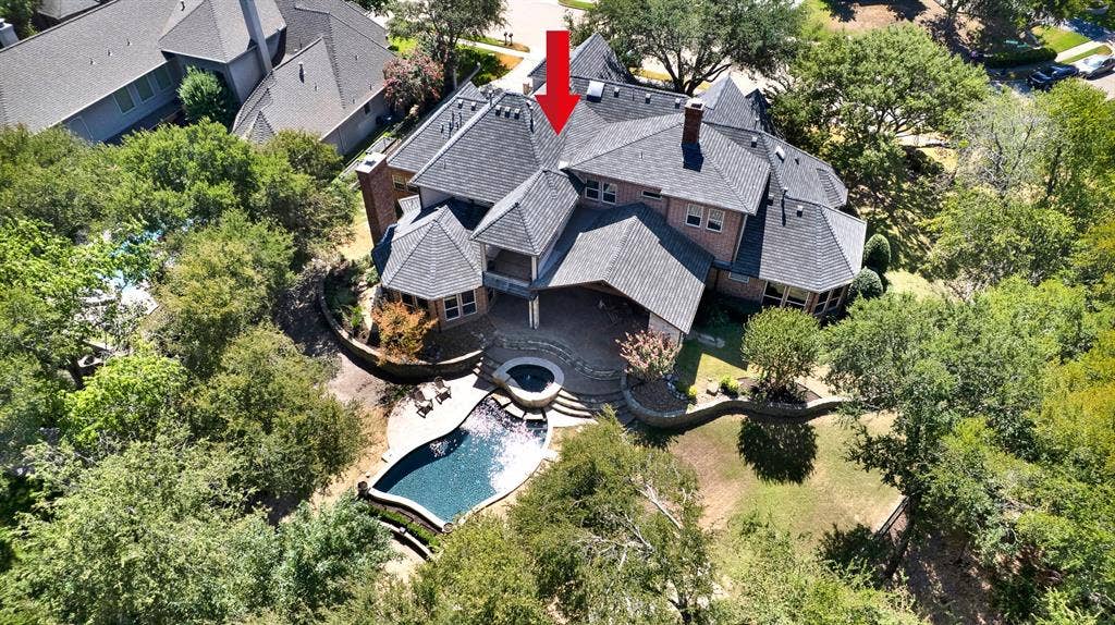 5237 SKY LAKE Drive, Plano, TX 75093 Intricate dark roof gables surround a central open patio courtyard bathed in soft natural light. Host casual afternoon pool parties where sun-seekers easily move between water, shade, and open lawn.