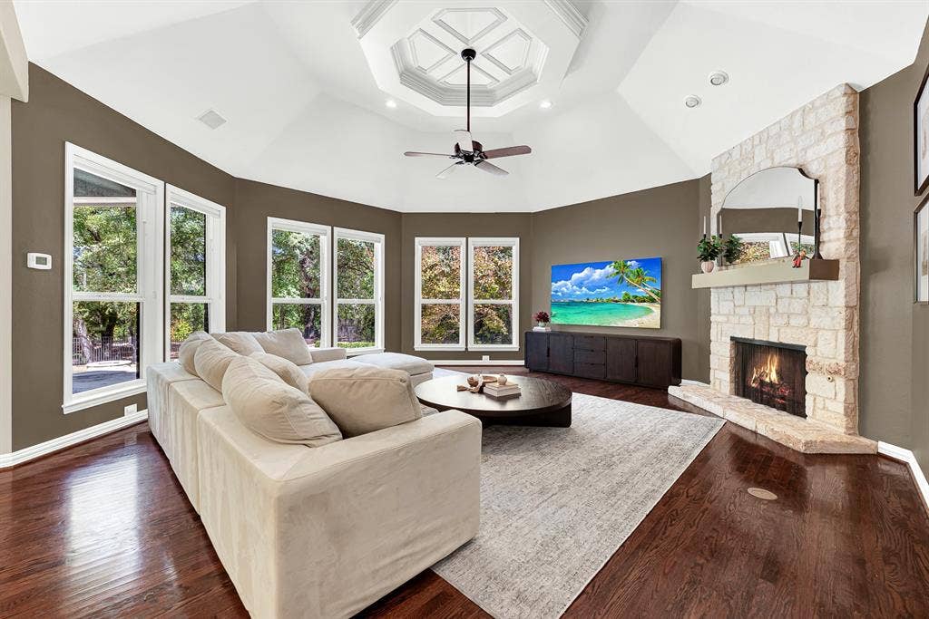 5237 SKY LAKE Drive, Plano, TX 75093 A rustic stone fireplace hearth rises to meet the soaring vaulted ceiling's detailed inset tray. Picture curling up here with a cozy blanket as flames dance on a chilly winter evening.