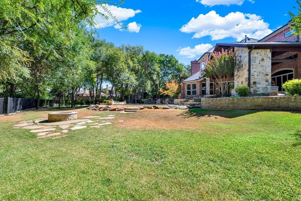 5237 SKY LAKE Drive, Plano, TX 75093 Flagstone pathways extend across the rolling backyard toward a dedicated stone fire pit ring. Unwind under clear night skies roasting marshmallows with family surrounded by quiet nature.
