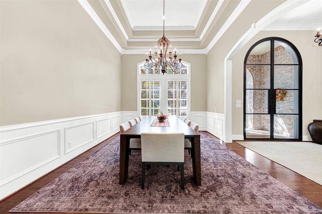 5237 SKY LAKE Drive, Plano, TX 75093 Layered tray ceilings and crisp wainscoting add tailored depth beneath a classic, glass-framed double door. You can almost hear the laughter during an intimate dinner party illuminated by soft chandelier light.