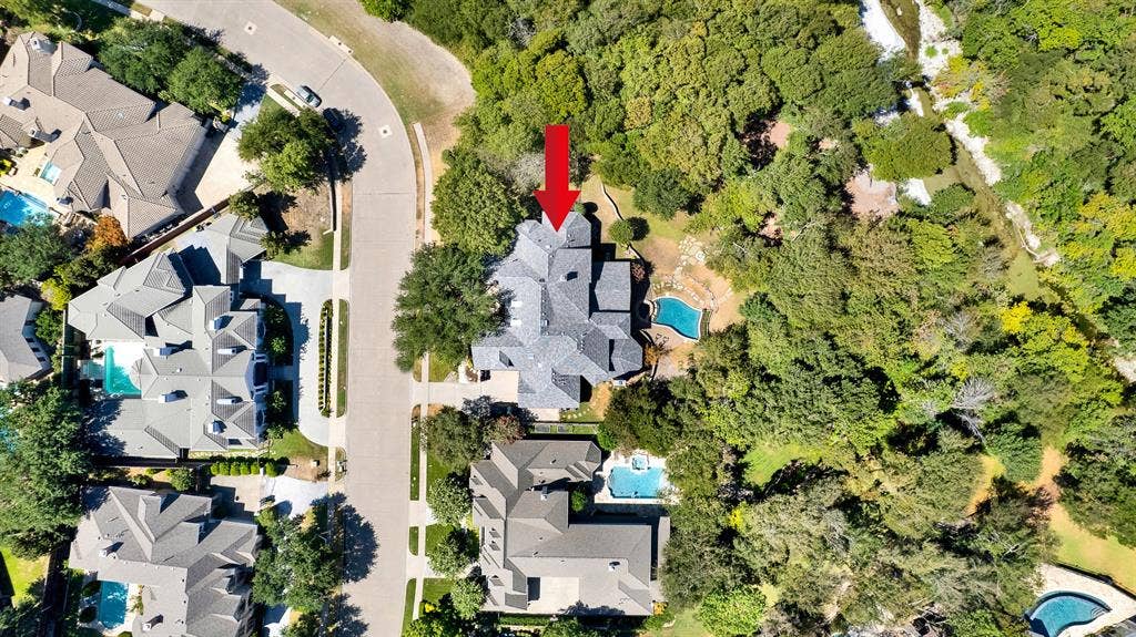 5237 SKY LAKE Drive, Plano, TX 75093 A top-down perspective showcases the intricate footprint nestled between a curving street and a winding creek bed. Start crisp mornings enjoying coffee as sunlight catches the sparkling blue pool tucked behind the trees.