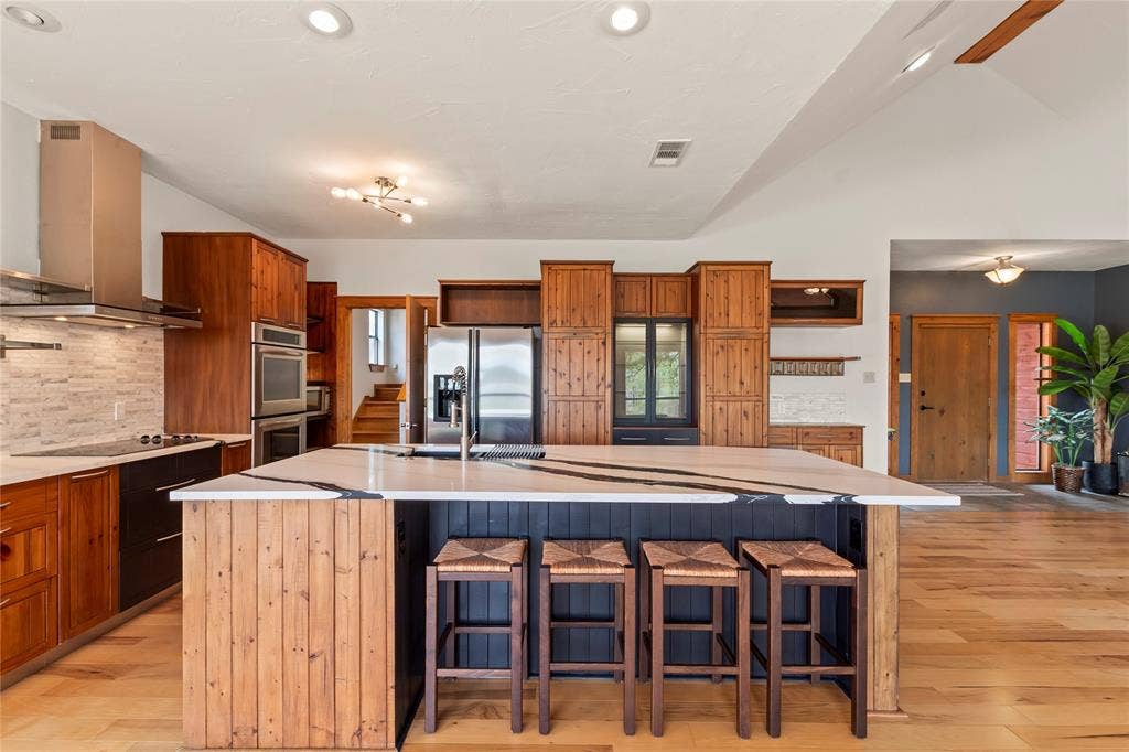 5459 Woodland Shores Drive, Log Cabin, TX 75148 Stainless steel appliances including double ovens and vent hood. Bar seating perfect for entertaining.