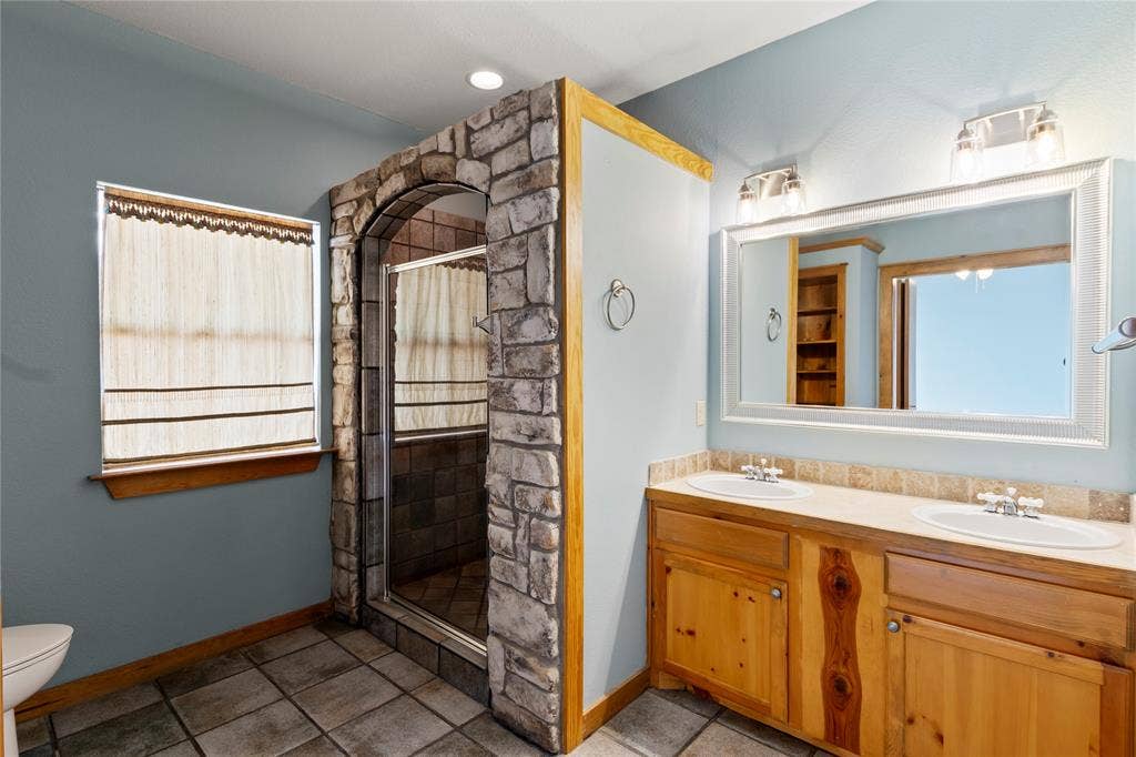5459 Woodland Shores Drive, Log Cabin, TX 75148 Spacious primary suite with walk in shower and double sink vanity.