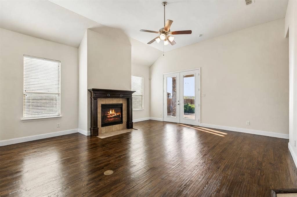 Vaulted ceilings, wood-finish flooring, and a fireplace with a decorative mantel